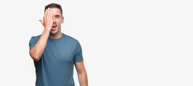 Yakışıklı genç casual adam yüz ve sürpriz duygu kendinden emin gülümseme ile el ile bir göz kapsayan.