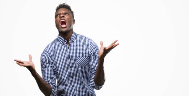 Mavi gömlek çılgın ve kızgın bağırarak ve agresif ifade ve silah kaldırdı bağırmaya giyen genç Afro-Amerikan adam. Hayal kırıklığı kavramı.