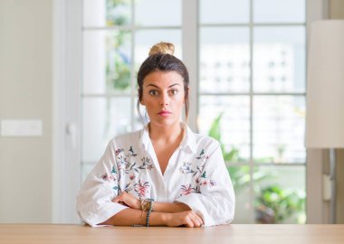 Genç kadın evde yüzünde ciddi bir ifade ile. Basit ve doğal kameraya bakıyor.