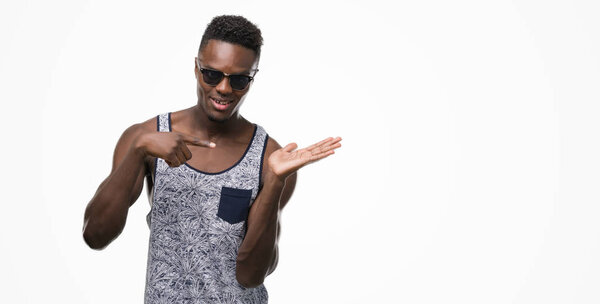 Young african american man very happy pointing with hand and finger