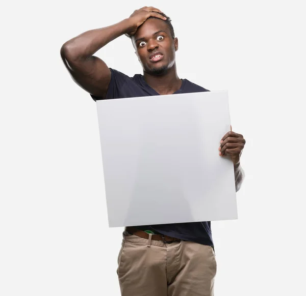 Young African American Man Holding Banner Stressed Hand Head Shocked — Stock Photo, Image