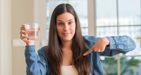 Young Woman Drinking Glass Water Home Surprise Face Pointing Finger — Stock Photo, Image