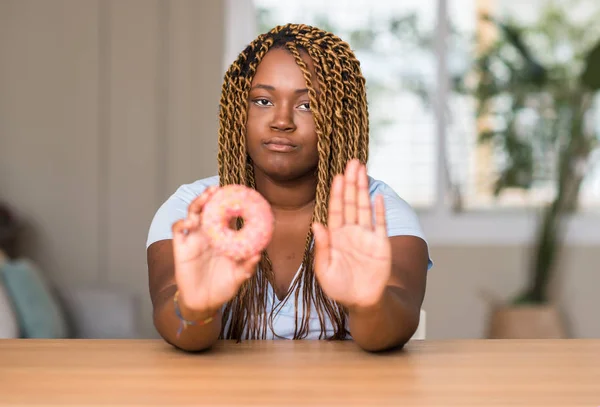 African American Vrouw Eten Donut Met Open Hand Doen Stopbord — Stockfoto