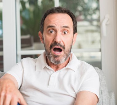 Yakışıklı orta yaş erkek bir sürpriz yüz, korkuyor ve heyecanlı korku ifadesi ile şok korkmuş