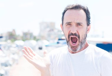 Yakışıklı orta yaş erkek marina çok mutlu ve heyecanlı, kazanan ifade ile büyük çığlık zaferini kutluyor gülümse ve el kaldırdı