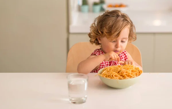自宅手でスパゲッ ティーを食べて美しい金髪の子供 — ストック写真