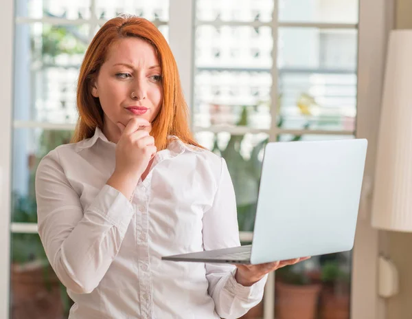 Κοκκινομάλλης Γυναίκα Χρησιμοποιώντας Υπολογιστή Φορητό Υπολογιστή Στο Σπίτι Σοβαρό Πρόσωπο — Φωτογραφία Αρχείου