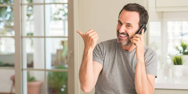 Hombre Mediana Edad Usando Smartphone Apuntando Con Mano Dedo Hacia —  Fotos de Stock