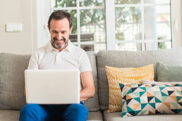 Homem Meia Idade Usando Laptop Sofá Com Rosto Feliz Sorrindo — Fotografia de Stock