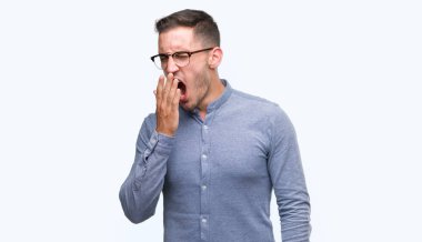 Gözlüklü zarif yakışıklı genç el ağzıyla kapsayan yorgun esneme sıkılmış. Restless ve uyku hali.