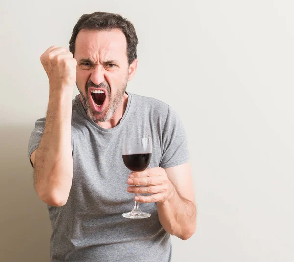 腹が立つグラスで赤ワインと狂気と怒り概念の上げられた手で叫んで 怒りと不満の叫びを飲む年配の男性 — ストック写真