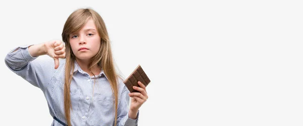 Young Blonde Child Holding Chocolate Bar Angry Face Negative Sign — Stock Photo, Image