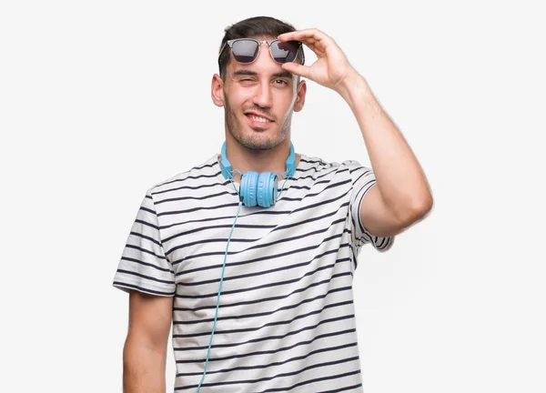 Joven Guapo Con Auriculares Guiñando Ojo Mirando Cámara Con Expresión —  Fotos de Stock