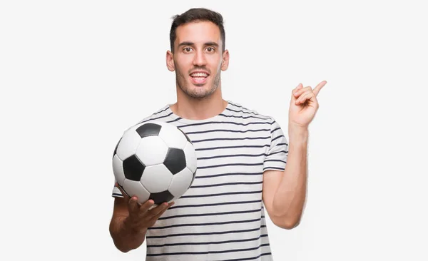 Guapo Joven Sosteniendo Fútbol Fútbol Muy Feliz Señalando Con Mano — Foto de Stock