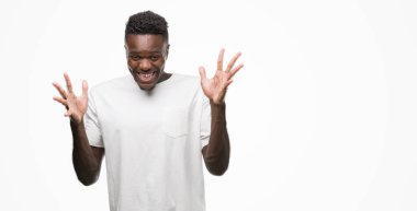 Beyaz giyen genç Afro-Amerikan adam deli ve silah ile başarı için hayran kutluyor t-shirt kaldırdı ve açık gözleri çığlık heyecanlı. Kazanan kavramı