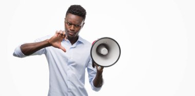 Başparmak aşağı, ret kavramı ile eksi işareti gösteren genç Afro-Amerikan adam holding megafon kızgın yüzü ile sevmemek