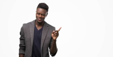 El ve parmak ile tarafına işaret çok mutlu bir ceket giyen genç Afro-Amerikan adam