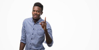 Mavi gömlek işaret parmağı ile başarılı fikir giyen genç Afro-Amerikan adam. Çıktıktan ve mutlu. Bir numara.