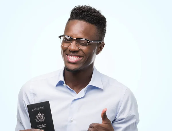 持有美利坚合众国护照的年轻非洲裔美国男子高兴与大微笑做 拇指与手指 优秀的标志 — 图库照片