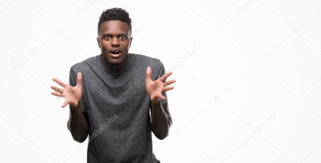 Young african american man wearing grey t-shirt celebrating crazy and amazed for success with arms raised and open eyes screaming excited. Winner concept