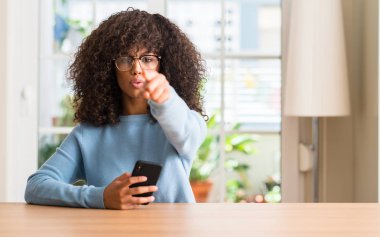 Kamera ve size, el işareti, pozitif ve kendinden emin bir jest ön parmak ile işaret smartphone kullanarak güzel bir Afrikalı-Amerikalı kadın