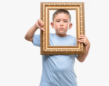 Başparmak aşağı, ret kavramı ile gösterilen eksi işareti koyu saçlı küçük çocuk holding çerçevesi kızgın yüzü ile sevmemek