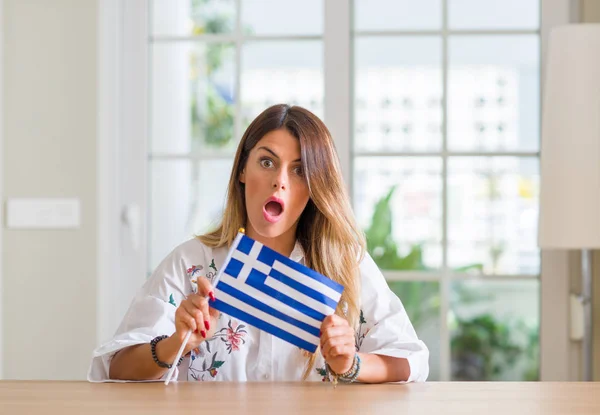 Νεαρή Γυναίκα Στο Σπίτι Κρατώντας Την Σημαία Της Ελλάδας Φοβάται — Φωτογραφία Αρχείου