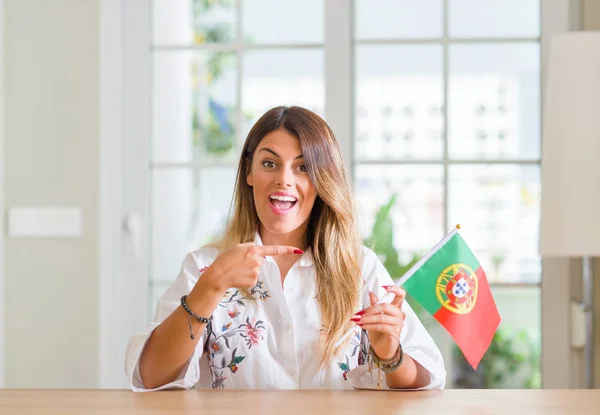 Молодая Женщина Дома Флагом Португалии Счастлива Указывая Рукой Пальцем — стоковое фото