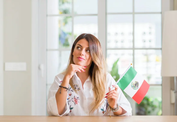 Jovem Mulher Casa Segurando Bandeira México Rosto Sério Pensando Questão — Fotografia de Stock