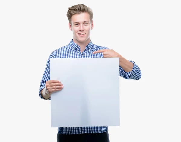 Young Handsome Blond Man Holding Banner Surprise Face Pointing Finger — Stock Photo, Image