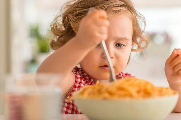 自宅のフォークでスパゲッティを食べて美しい金髪の子供 — ストック写真