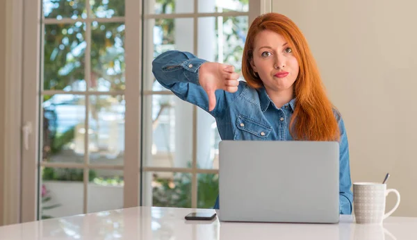 红发女人用电脑膝上型电脑在家里带着愤怒的脸 否定的手势显示不喜欢拇指向下 拒绝概念 — 图库照片