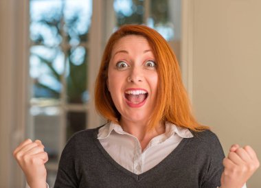 Heyecanlı gurur çığlık ve zafer ve başarı çok kutluyor, Kızıl saçlı kadın evde tezahürat duygu