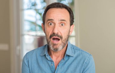 Yakışıklı orta yaş erkek bir sürpriz yüz, korkuyor ve heyecanlı korku ifadesi ile şok korkmuş