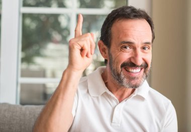 Yakışıklı ortadaki adam bir fikirle sürpriz yaş ya da gülen yüz, bir numara ile işaret parmağı soru