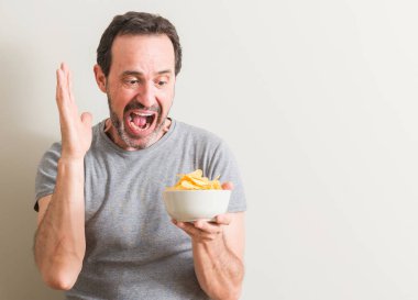 Patates cipsi çok mutlu ve heyecanlı, kazanan ifade büyük gülümseme ile çığlık zaferini kutluyor yeme ve ellerini kaldırdı komuta sizde