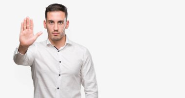 Yakışıklı genç iş adamı açık eliyle dur işareti ile ciddi ve kendine güvenen ifade, savunma hareketi yapıyor