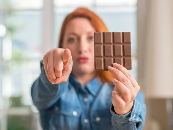 Mulher Ruiva Segurando Barra Chocolate Casa Apontando Com Dedo Para — Fotografia de Stock