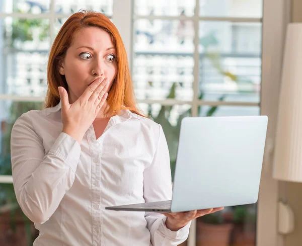 红头发的女人用电脑笔记本电脑在家里捂着嘴 手里带着羞愧的错误 表达恐惧 害怕沉默 秘密概念 — 图库照片