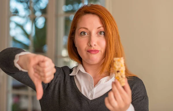 赤毛の女性の怒った顔自宅 不承諾と負の符号を示す嫌悪感 拒絶反応概念シリアルバーを食べる — ストック写真