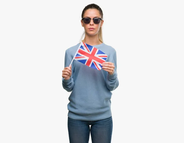 深刻な考えるスマートの顔に自信を持って式の英国旗を保持している美しい若い女性 — ストック写真