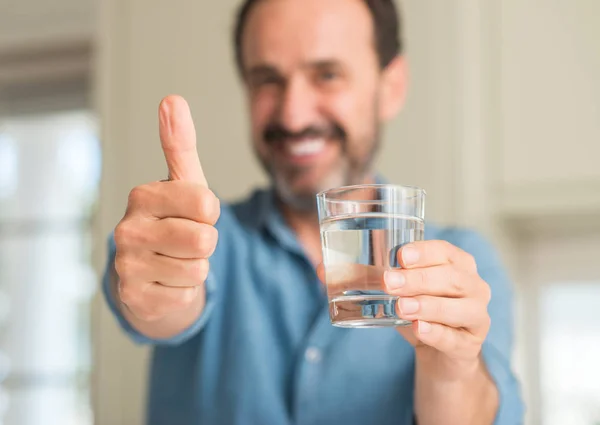 笑顔の サイン 優秀な兆候を親指をやって幸せな水のガラスを飲む中年男性 — ストック写真