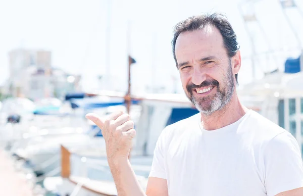 英俊的中年男子在码头指着手和手指与快乐的脸微笑 — 图库照片