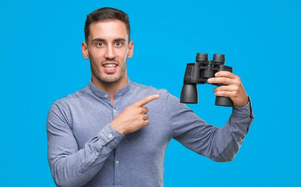 Bonito Jovem Olhando Através Binóculos Muito Feliz Apontando Com Mão — Fotografia de Stock