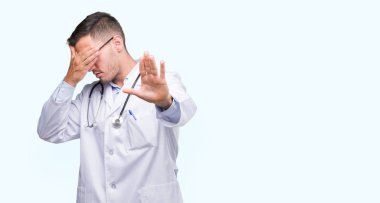Yakışıklı genç doktor adam elleriyle gözlerini kapsayan ve stop jest ile acı ve korku ifadesi. Utandım ve negatif kavramı.