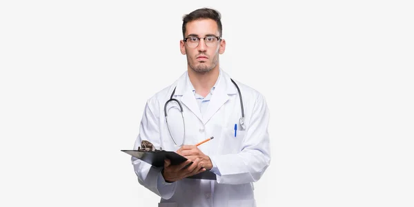 Bonito Jovem Médico Homem Segurando Uma Prancheta Com Uma Expressão — Fotografia de Stock