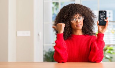 Kırık smartphone el ve parmak ile yukarı dönük ile gülümseyen mutlu yüz tutan Afrikalı-Amerikalı kadın