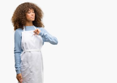 Zafer yüzü ile işaret gurur, heyecanlı ve küstah, bir önlük giyen Afro-Amerikan dükkanı sahibi kadın