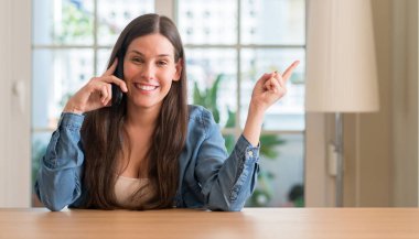 El ve parmak ile tarafına işaret çok mutlu Smartphone kullanan genç kadın