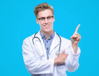 Genç yakışıklı sarışın doktor el ve parmak ile tarafına işaret çok mutlu